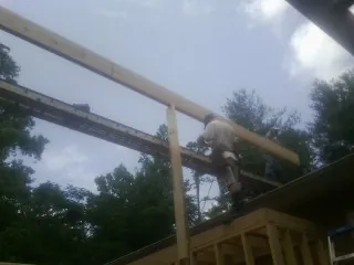 Carpenter setting a ridge beam over a new addition frame — Ice Dam Removal by Roofing Brothers in Letart