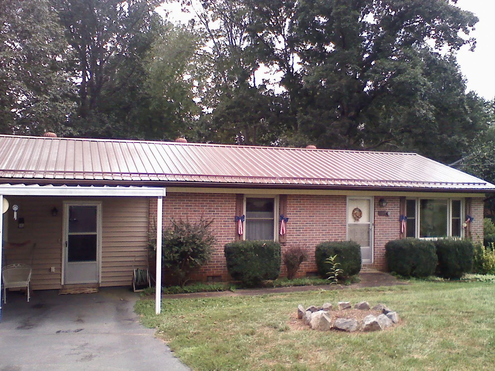 Bronze metal roof and carport on a brick ranch home — Roof Repair work by our crew in Letart